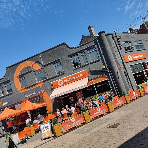 Baobab Cafe storefront on Loughborough's Market Street with bright orange awning and outdoor seating