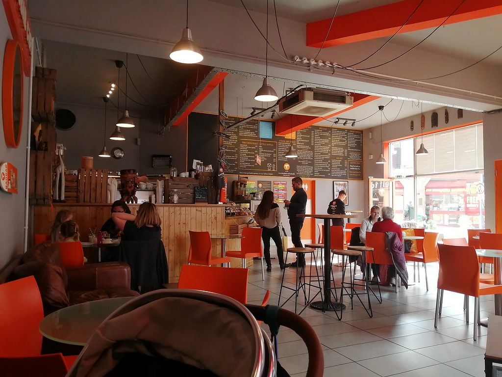 Inside Baobab Cafe — orange chairs, wooden counter and chalkboard menu